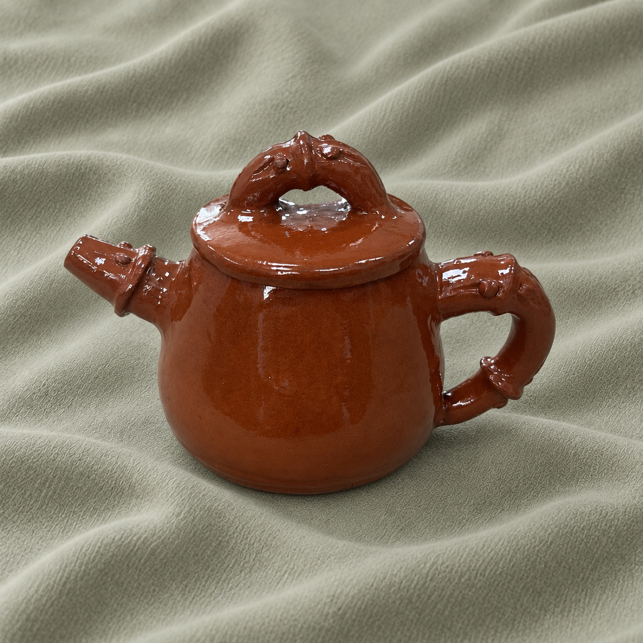 Warm brown ceramic teapot with sculptural handles