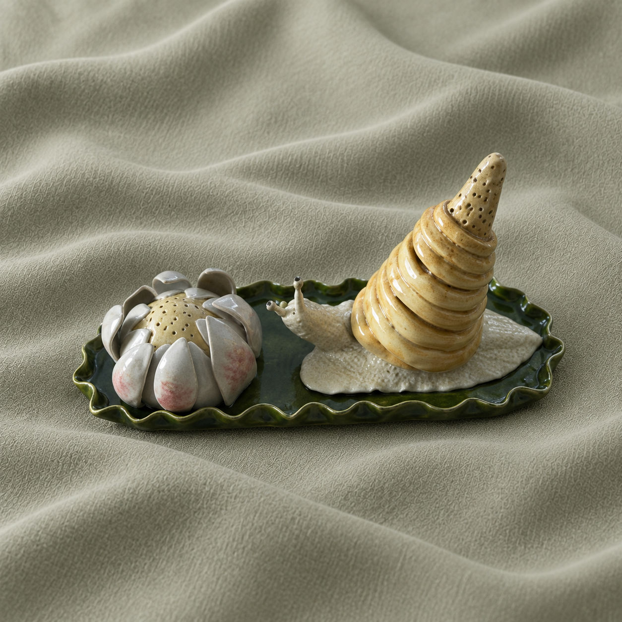 Ceramic snail and flower on a green leaf-shaped base